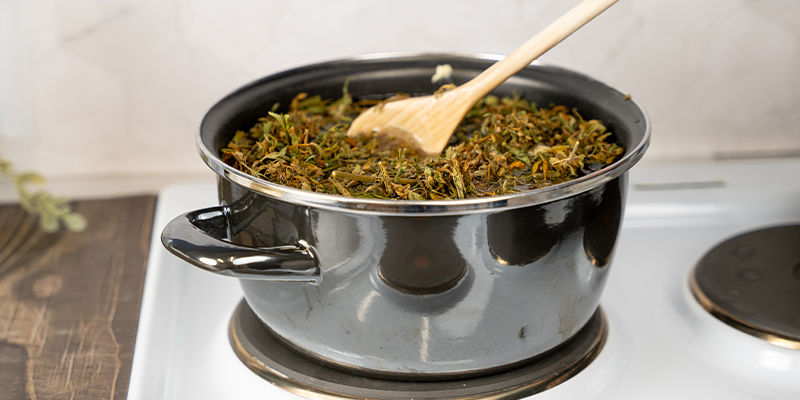 Sekoita seosta säännöllisesti puulusikalla ja lisää kuumaa vettä, kun määrä on vähentynyt noin puoleen. As you boil the mixture, stir it regularly with your wooden spoon and keep topping it up with hot water when it reduces by half the original volume.