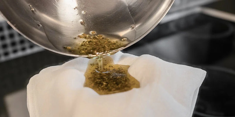 Siivilöi pois kaikki kasvimateriaali harsokankaan tai tiheän siivilän avulla, sillä THC on nyt uutettu. Use a cheesecloth or fine strainer to remove all plant material, as the THC will now have been extracted.